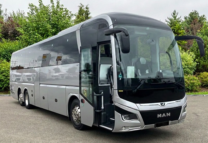 Silver three-axle MAN Lion's Coach, front three-quarter view from the door side